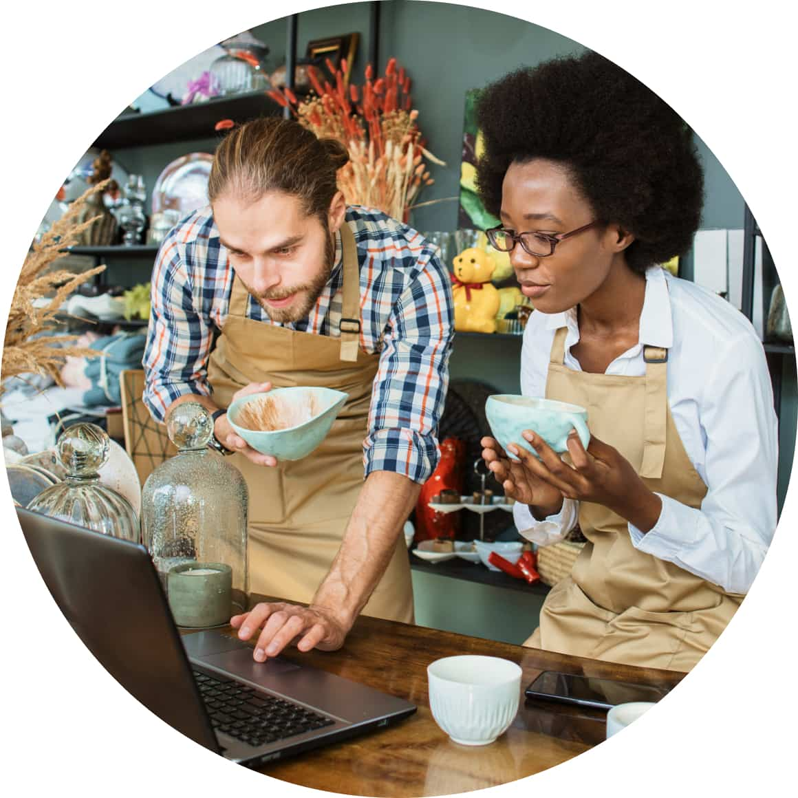 Retail employees checking inventory on laptop 