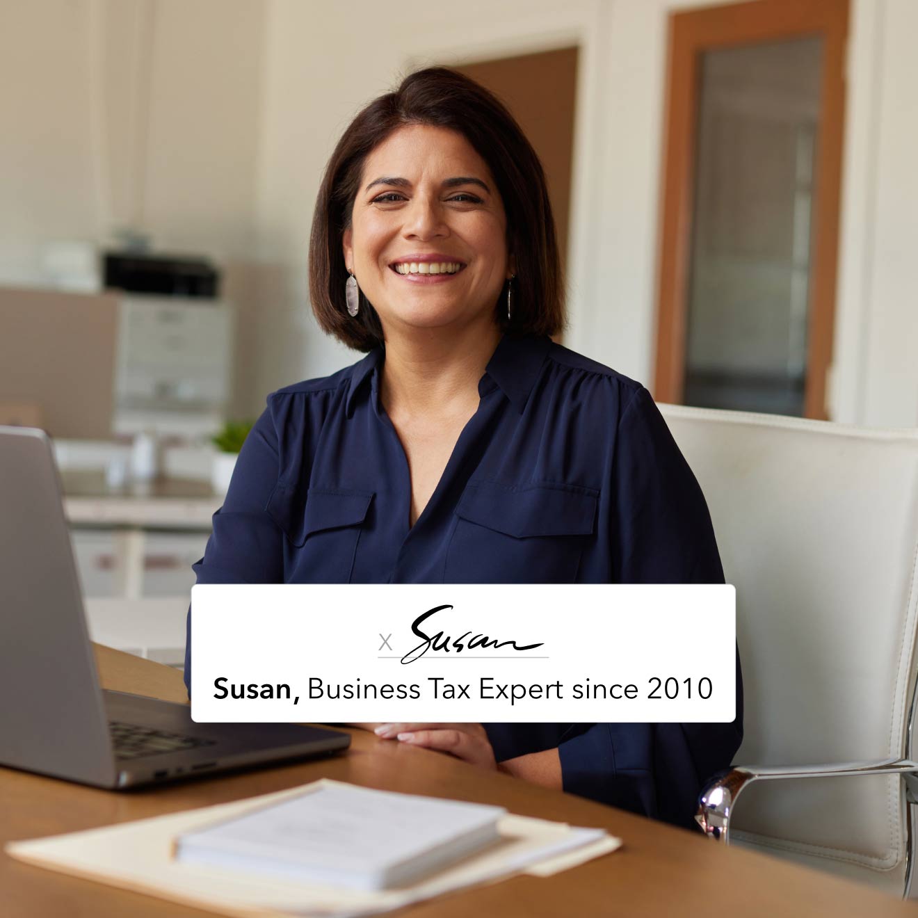 A QuickBooks business tax expert is sitting at a desk in front of an open laptop computer